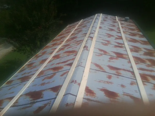 Rusted metal roof panels with new wood purlins before replacement — Storm Damage Roof Repair in Lexington by Roofing Brothers